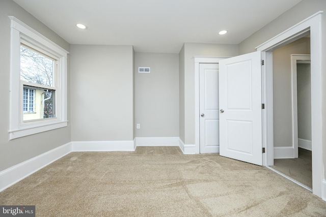 unfurnished bedroom with recessed lighting, carpet floors, visible vents, baseboards, and a closet