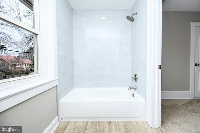 full bath featuring  shower combination, baseboards, and wood finished floors