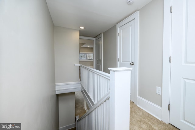 corridor with carpet floors, recessed lighting, baseboards, and an upstairs landing