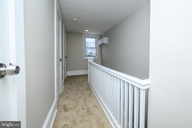 hall with carpet floors, a wall unit AC, and baseboards