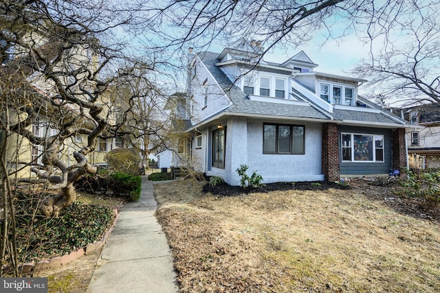 view of home's exterior with a shingled roof and stucco siding