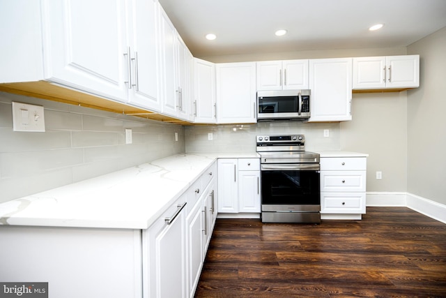 kitchen with stainless steel appliances, white cabinets, decorative backsplash, and light stone counters