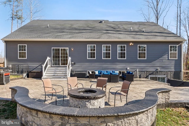 rear view of property with an outdoor living space with a fire pit, a patio, and roof with shingles