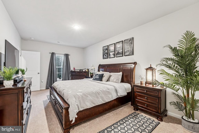 bedroom with light colored carpet and baseboards