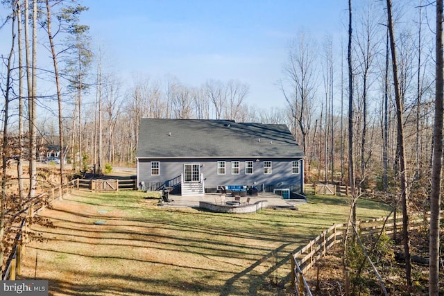 rear view of property with entry steps, a lawn, and fence