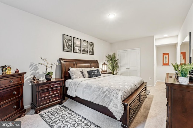 bedroom featuring light carpet, baseboards, and a closet