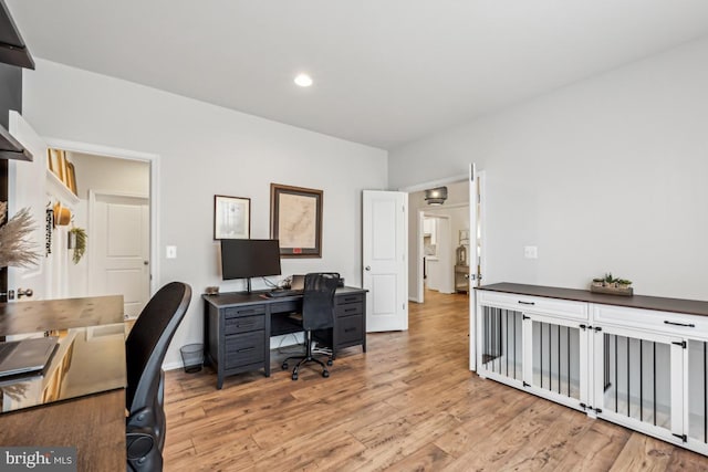 office with light wood-type flooring and recessed lighting