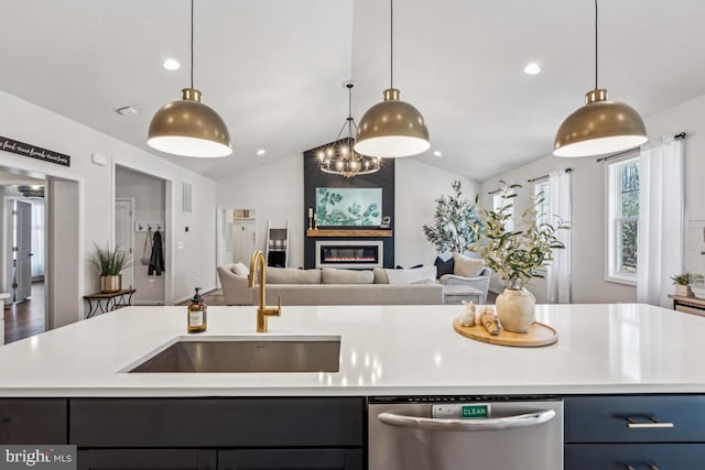 kitchen with open floor plan, light countertops, a sink, and stainless steel dishwasher