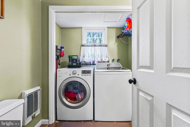 laundry room with laundry area, heating unit, and independent washer and dryer