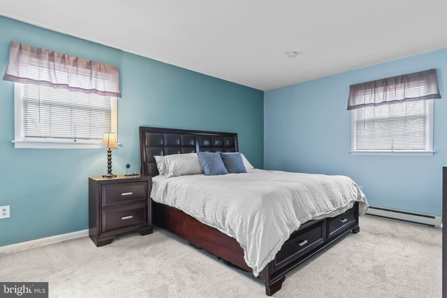 bedroom with baseboards, light carpet, and baseboard heating