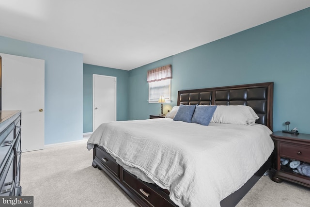 bedroom with light colored carpet and baseboards