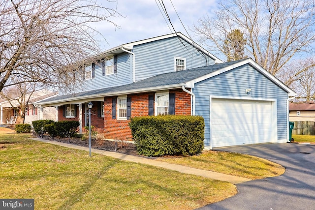 traditional-style home featuring driveway, brick siding, an attached garage, and a front lawn