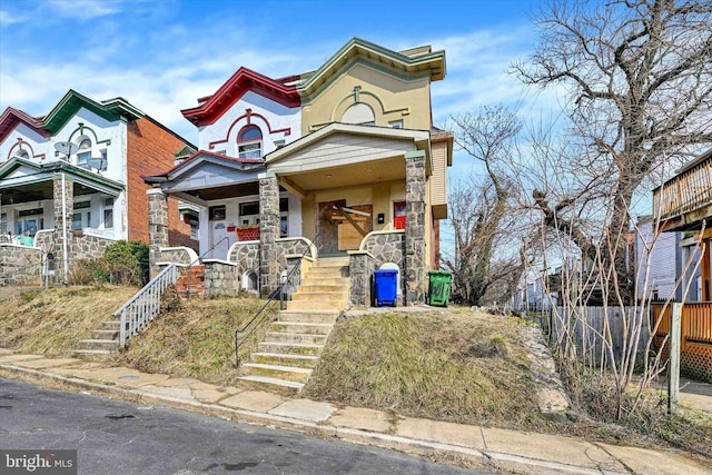 view of front of home with stone siding and covered porch