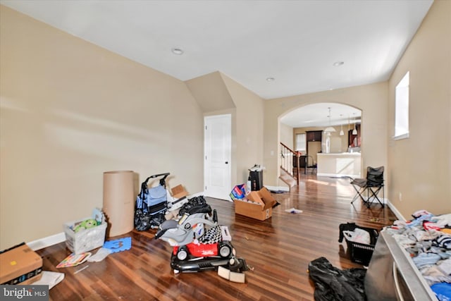 interior space with stairs, arched walkways, baseboards, and wood finished floors