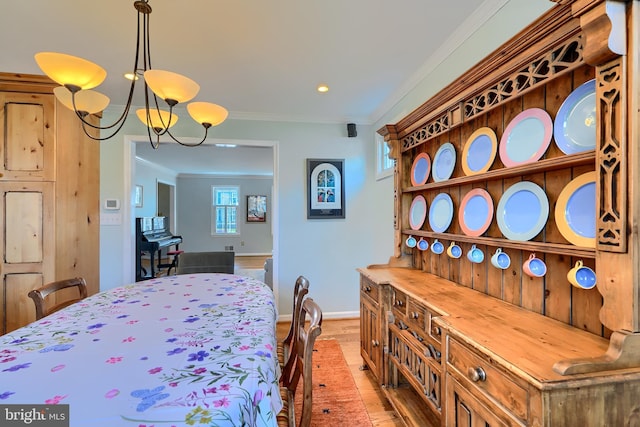 bedroom featuring crown molding, light wood-type flooring, baseboards, and a chandelier