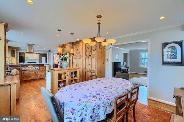 dining room with recessed lighting, light wood-style flooring, crown molding, and baseboards