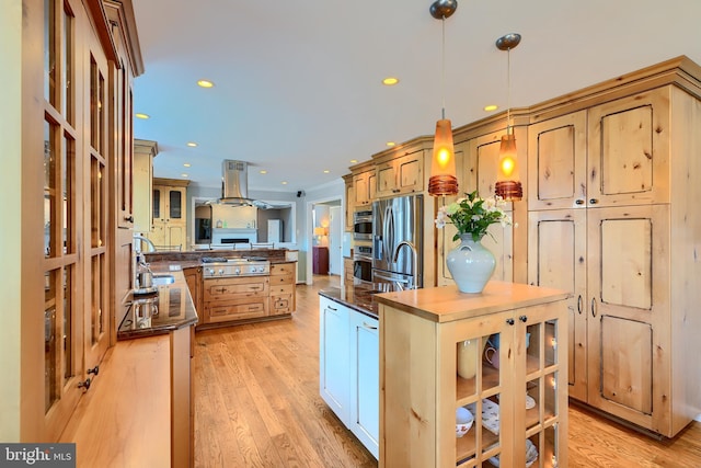 kitchen featuring dark countertops, appliances with stainless steel finishes, island exhaust hood, light wood-style floors, and a sink