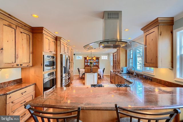 kitchen featuring recessed lighting, appliances with stainless steel finishes, island exhaust hood, a peninsula, and a sink