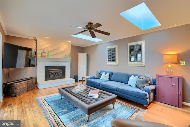 living area with crown molding and a skylight