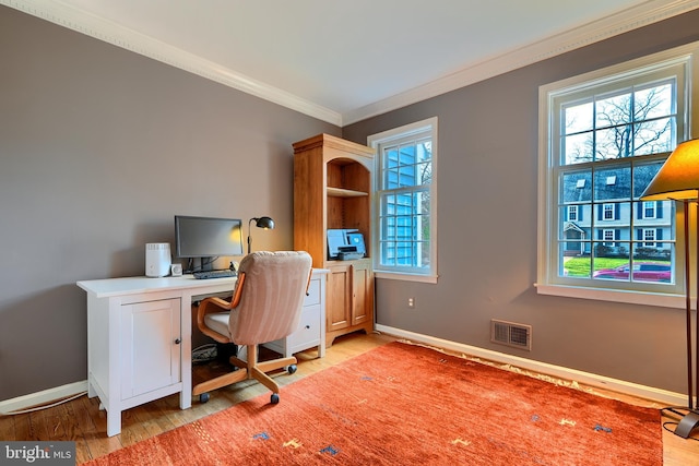 home office with light wood-type flooring, baseboards, visible vents, and ornamental molding