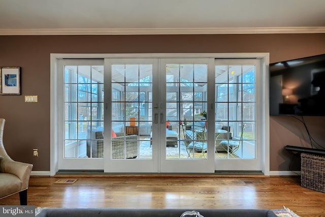 entryway with visible vents, ornamental molding, french doors, wood finished floors, and plenty of natural light