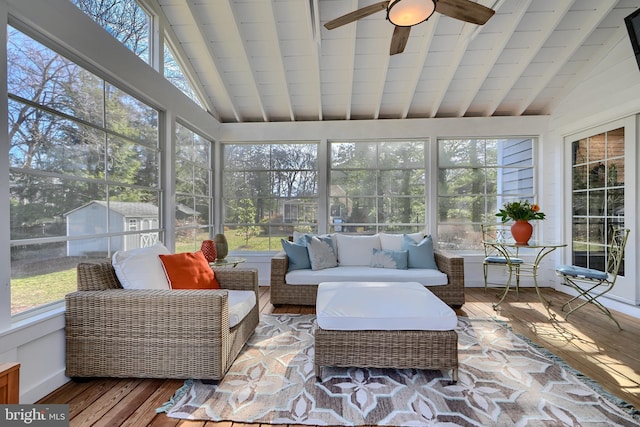 sunroom / solarium with vaulted ceiling with beams and a ceiling fan