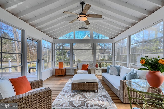 sunroom featuring lofted ceiling with beams and a ceiling fan