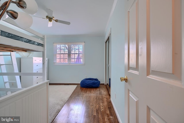 bedroom with ceiling fan, wood finished floors, baseboards, and ornamental molding