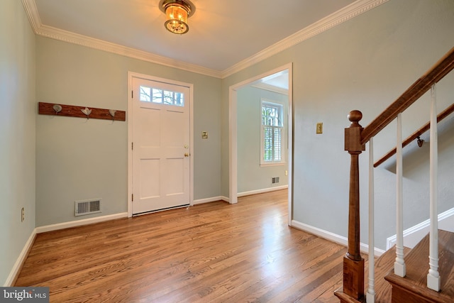 entrance foyer with stairway, wood finished floors, visible vents, baseboards, and crown molding