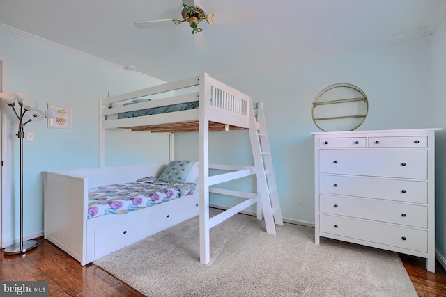 bedroom with baseboards, wood finished floors, a ceiling fan, and ornamental molding