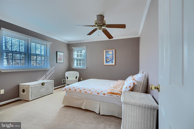 carpeted bedroom featuring a ceiling fan, baseboards, and ornamental molding