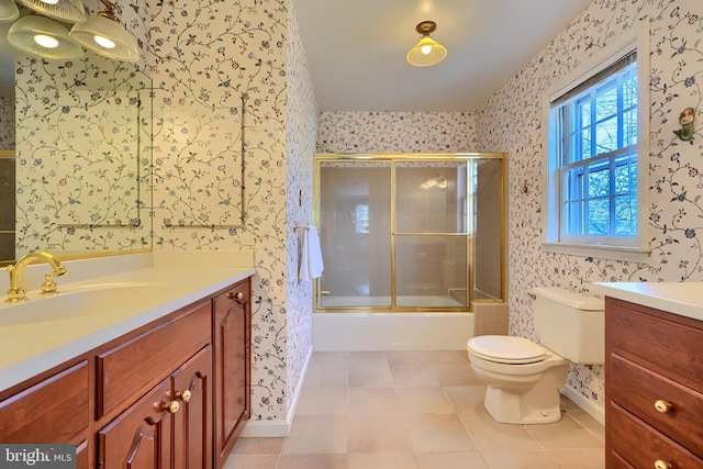 full bathroom with wallpapered walls, toilet, vanity, and shower / bath combination with glass door