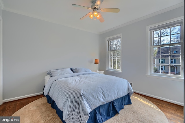 bedroom featuring crown molding, baseboards, and wood finished floors