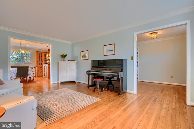 living area featuring an inviting chandelier, baseboards, wood-type flooring, and ornamental molding