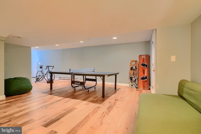 rec room featuring visible vents, light wood finished floors, baseboards, recessed lighting, and a baseboard heating unit