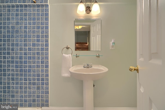 full bathroom with tiled shower and a sink