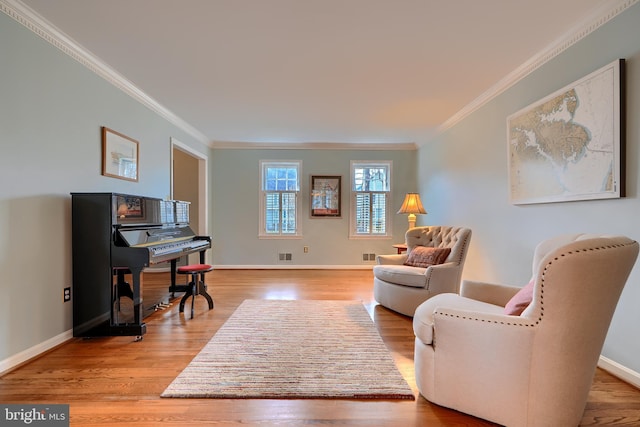 office area with visible vents, baseboards, wood finished floors, and crown molding