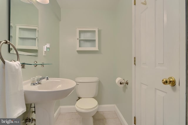 bathroom featuring tile patterned floors, toilet, and baseboards