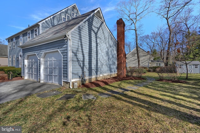 view of home's exterior featuring a lawn, driveway, a shed, an outdoor structure, and a garage