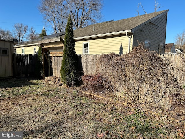 view of property exterior featuring fence private yard and an outdoor structure