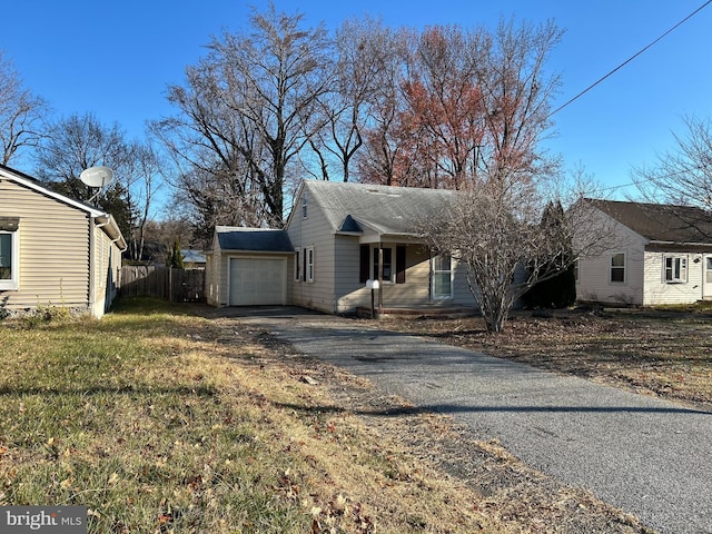 view of front of house with driveway, a garage, and fence