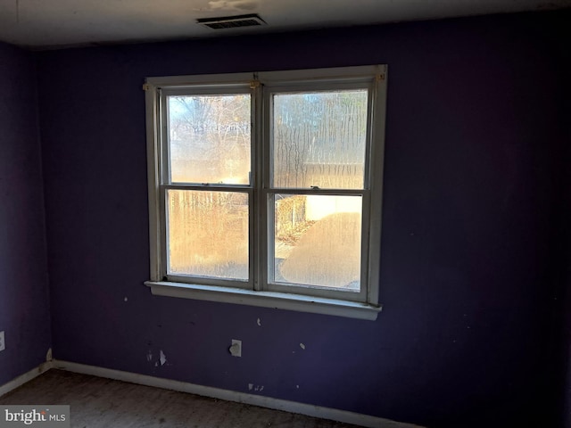 spare room featuring visible vents and baseboards