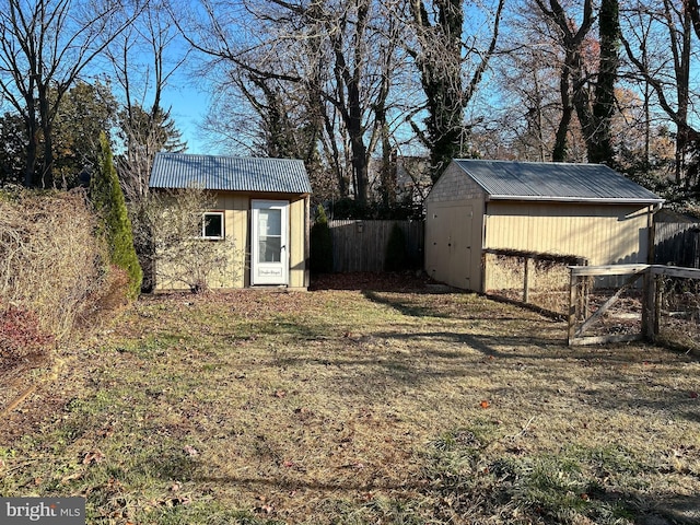 view of yard featuring an outbuilding, fence, and a storage unit