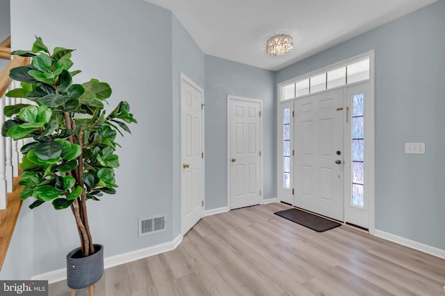 foyer entrance featuring baseboards, visible vents, and light wood-type flooring