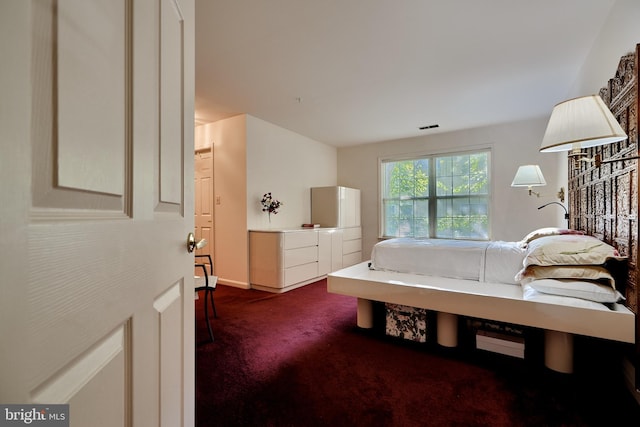 bedroom with visible vents and dark carpet