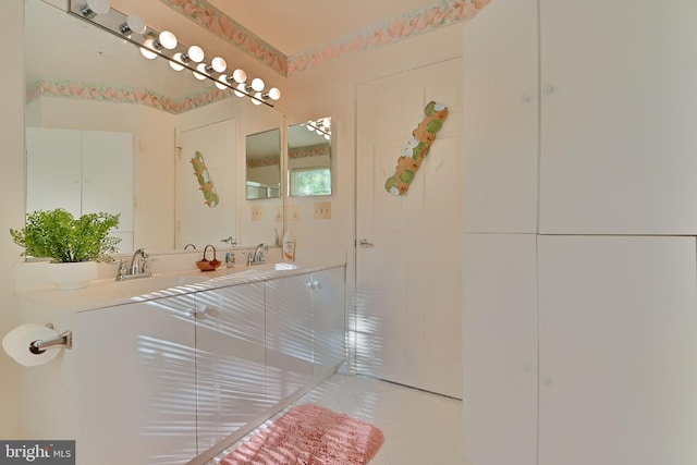 bathroom featuring double vanity, a sink, and tile patterned floors