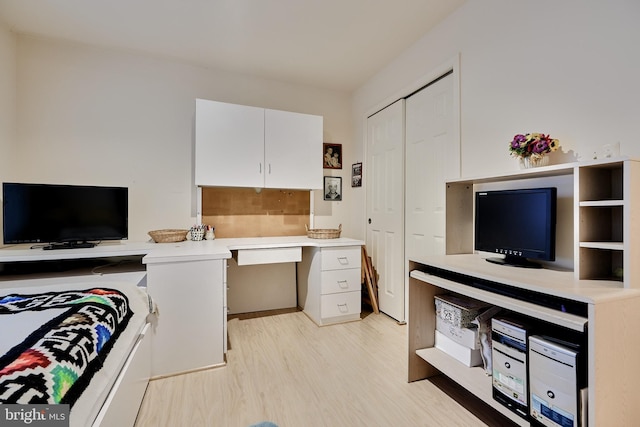 office featuring light wood finished floors and built in desk