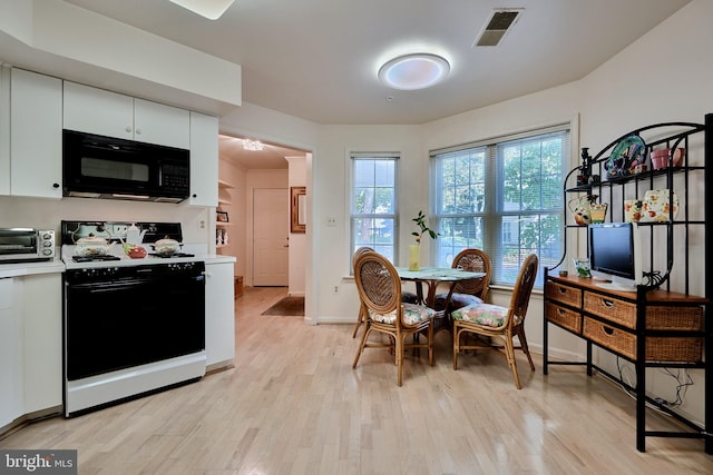 dining space featuring a toaster, light wood-type flooring, visible vents, and a healthy amount of sunlight