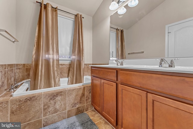 bathroom with double vanity, tiled shower / bath combo, a sink, and tile patterned floors