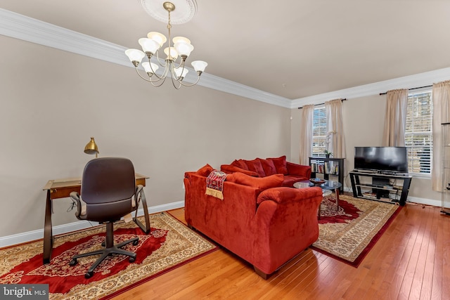 living area featuring hardwood / wood-style flooring, baseboards, crown molding, and an inviting chandelier